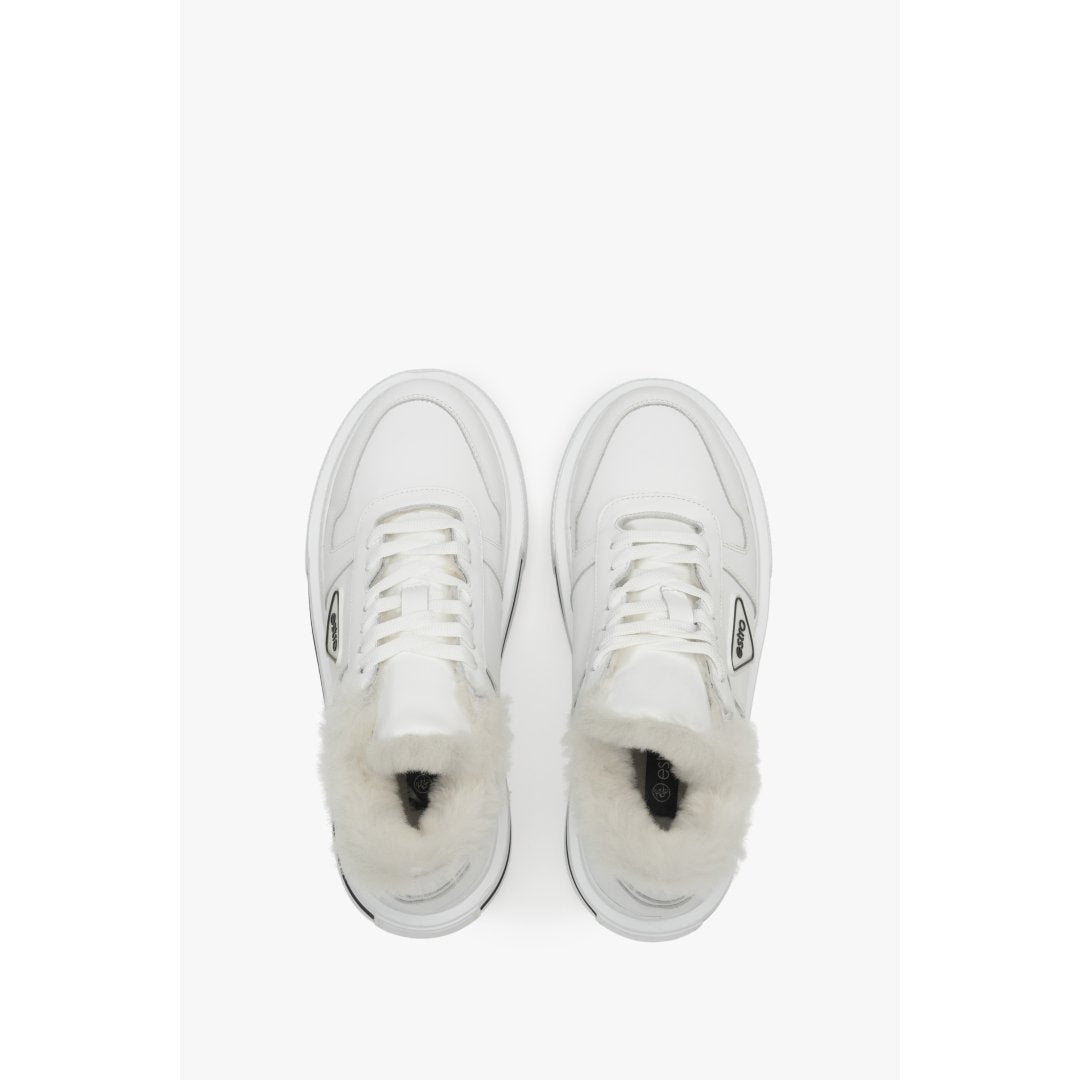 White insulated women's sneakers made from genuine leather with fur lining - presentation of the footwear from above.