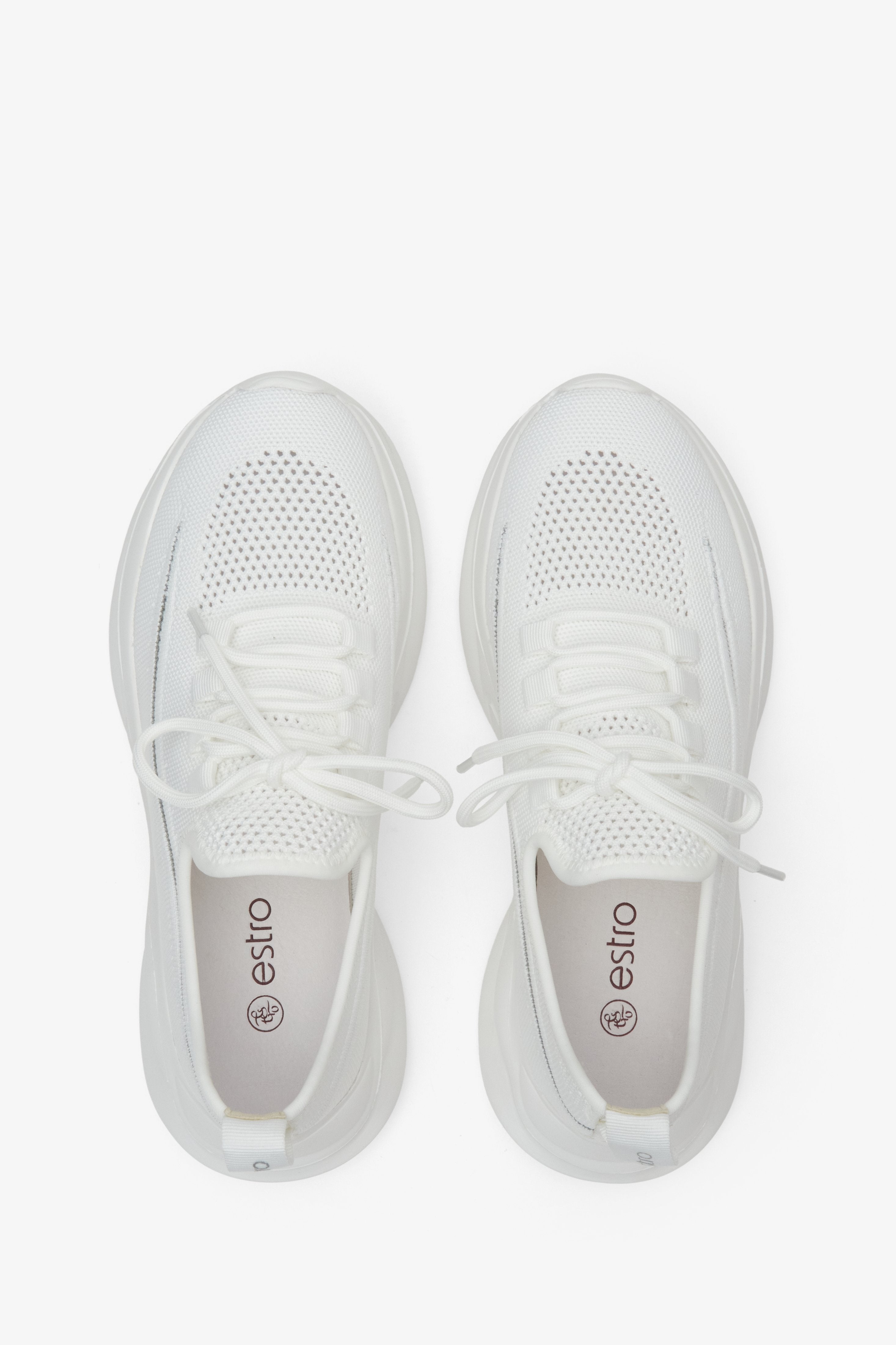 Women's white low top sneakers made of mesh and textile - presentation of the footwear from above.