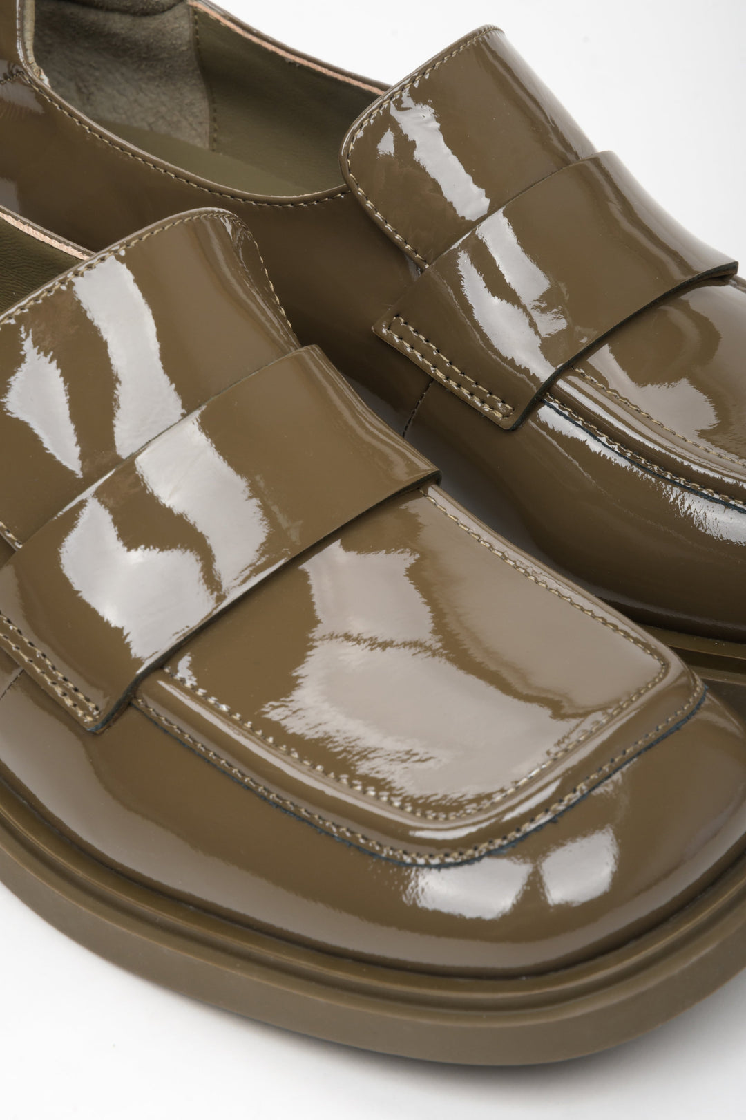 Women's dark green patent leather moccasins by Estro - close-up on details.