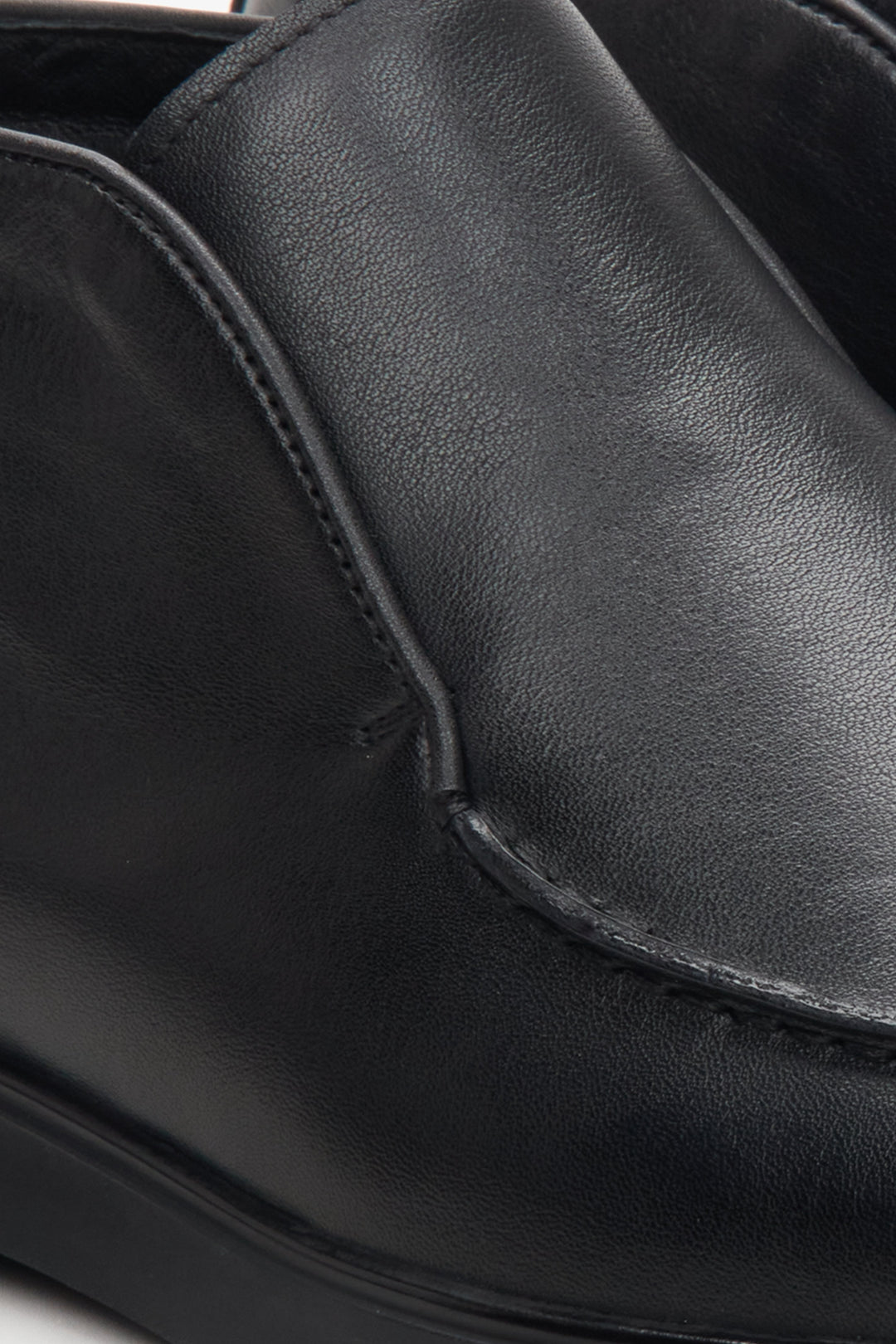 Men's black boots made of genuine leather in black color - close-up on the toe of the shoe.