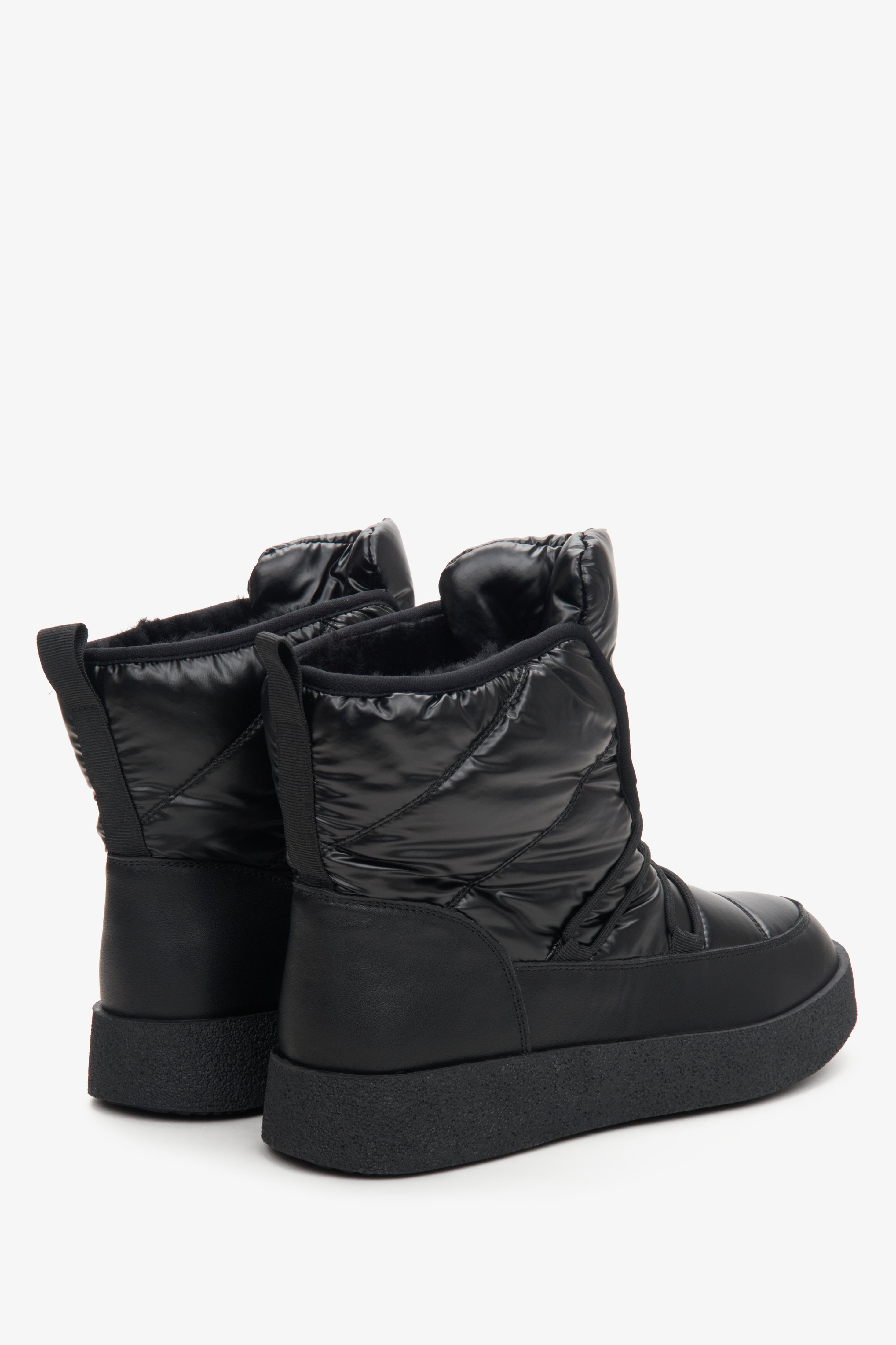 Women's black leather snow boots with a glossy finish - close-up on the heel and side line of the shoe.