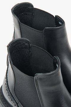 A pair of women's short black Chelsea boots with decorative perforations on the Italian leather upper.