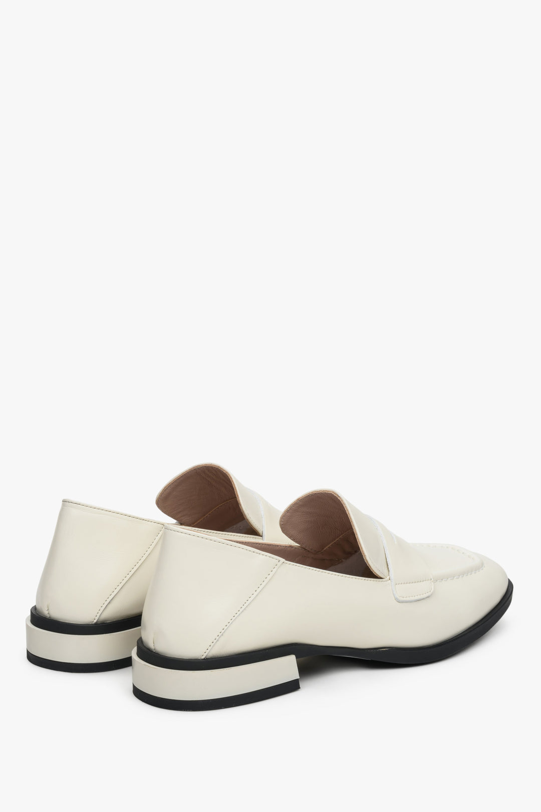 Women's white loafers made of genuine leather with a low heel - close-up on the heel and side seam.