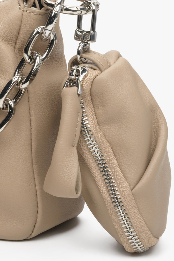 Small, stylish women's beige leather bag with a chain strap - close-up of the additional pouch.