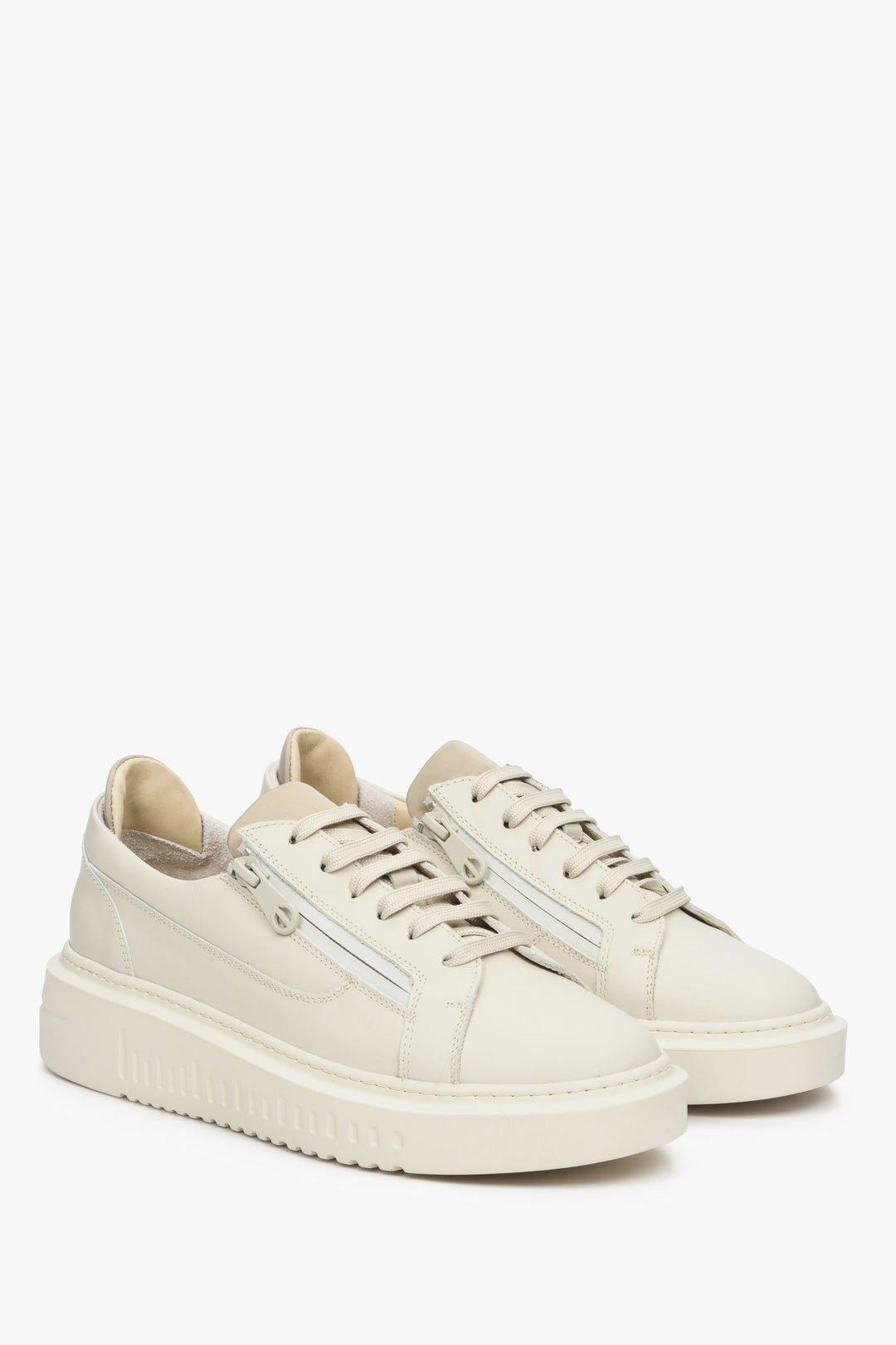 Leather, women's beige sneakers by Estro with laces and decorative zipper - presentation of the shoe's toe and side seam.