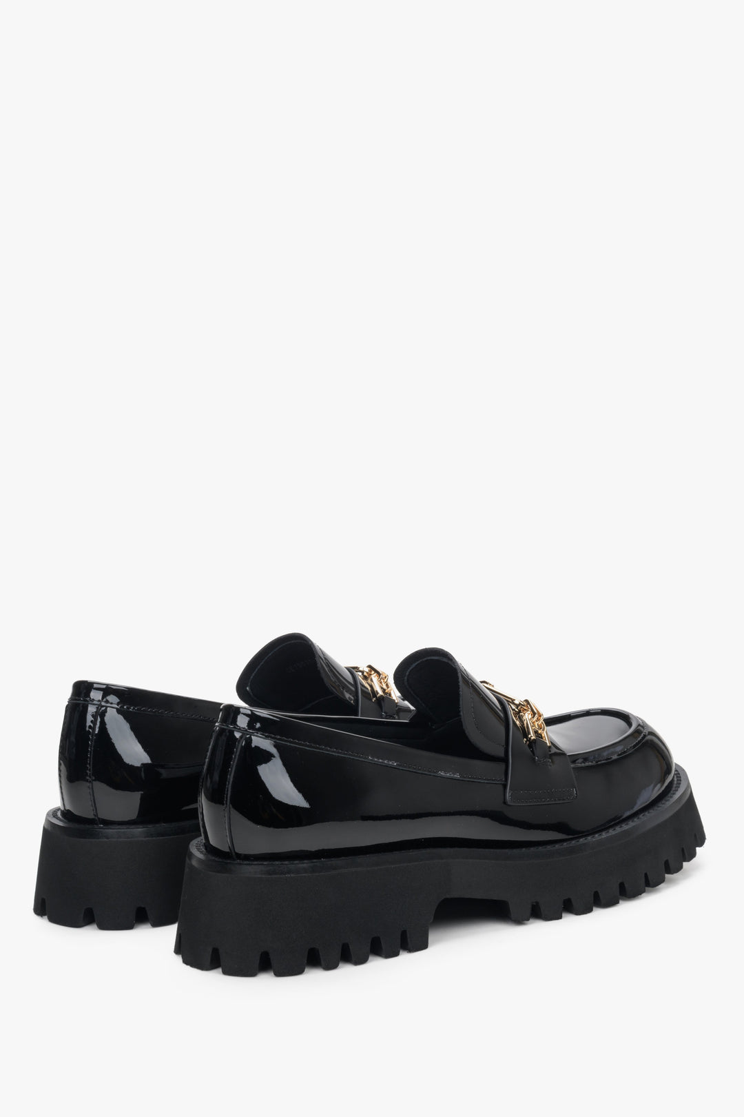 Women's black leather moccasins by Estro with a gold buckle - close-up on the heel.