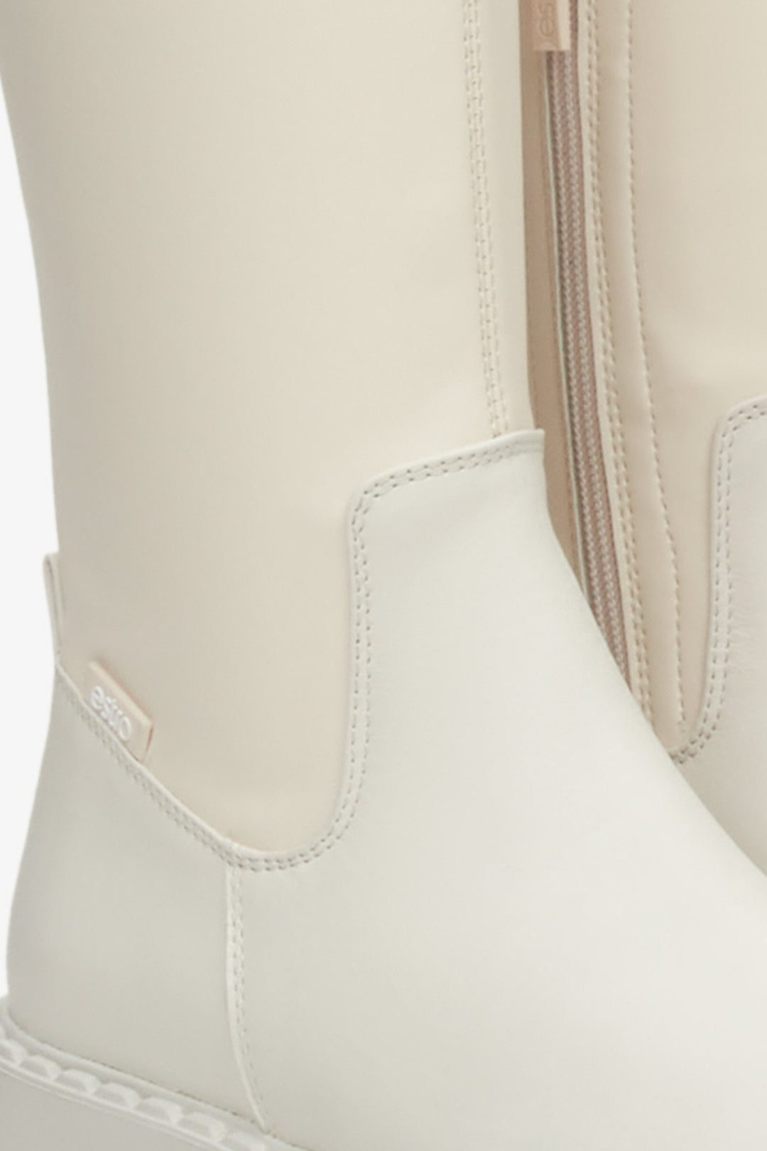 Women's high beige boots made of soft leather, reaching above the knee - close-up on the detail.