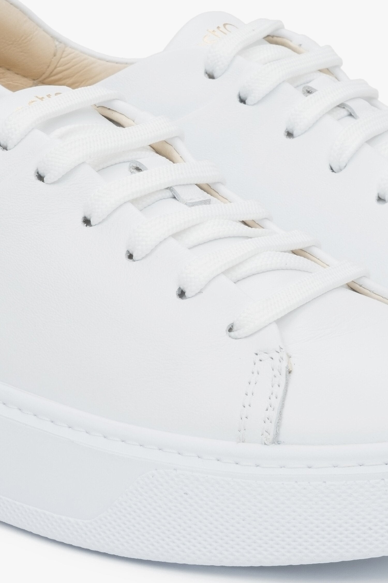 Close-up on details of white women's sneakers made of genuine leather Estro.