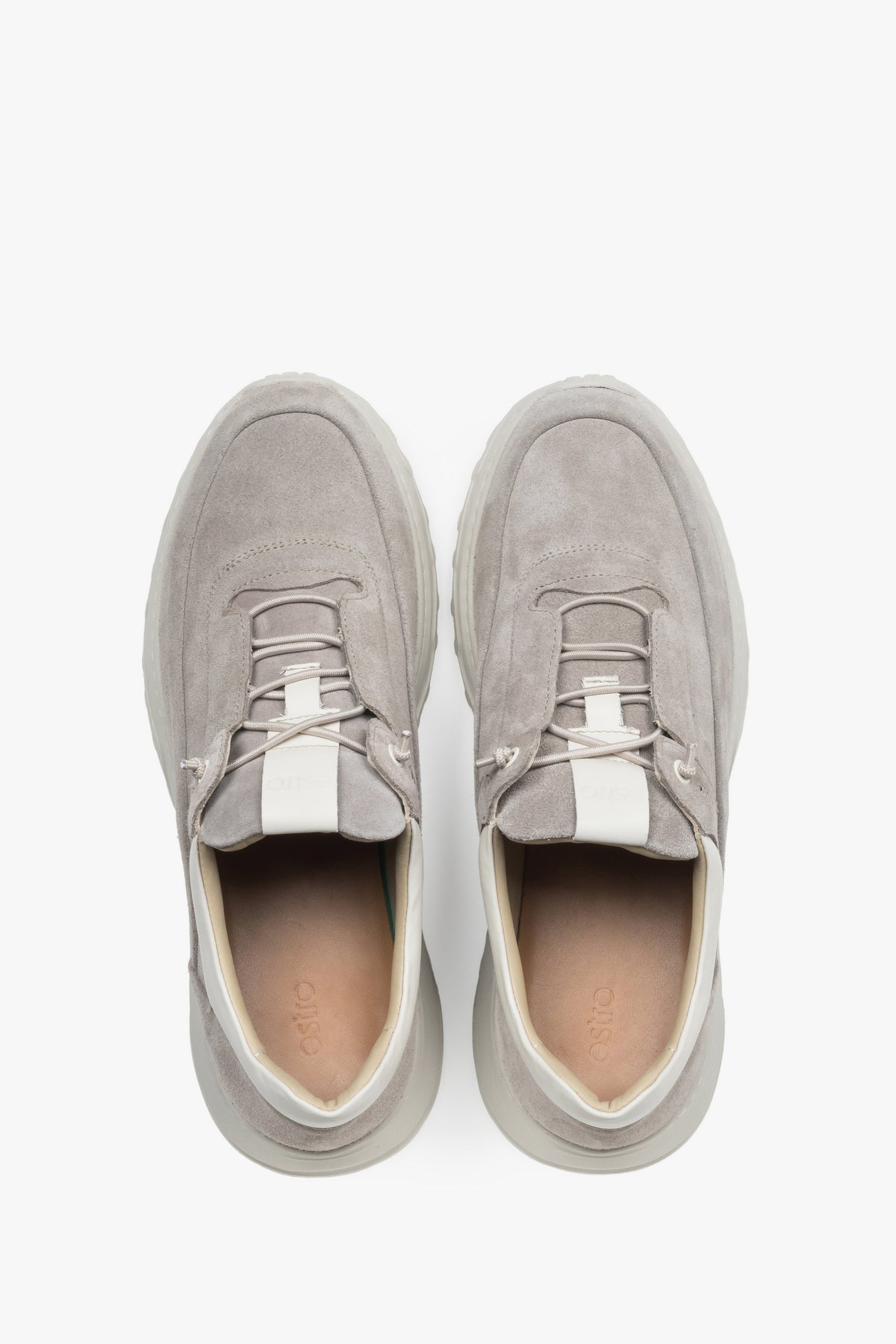 Stylish beige men’s sneakers with a grooved, flexible sole for comfort.