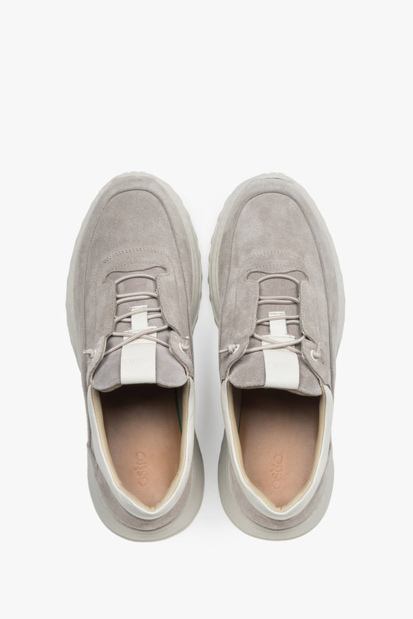 Stylish beige men’s sneakers with a grooved, flexible sole for comfort.