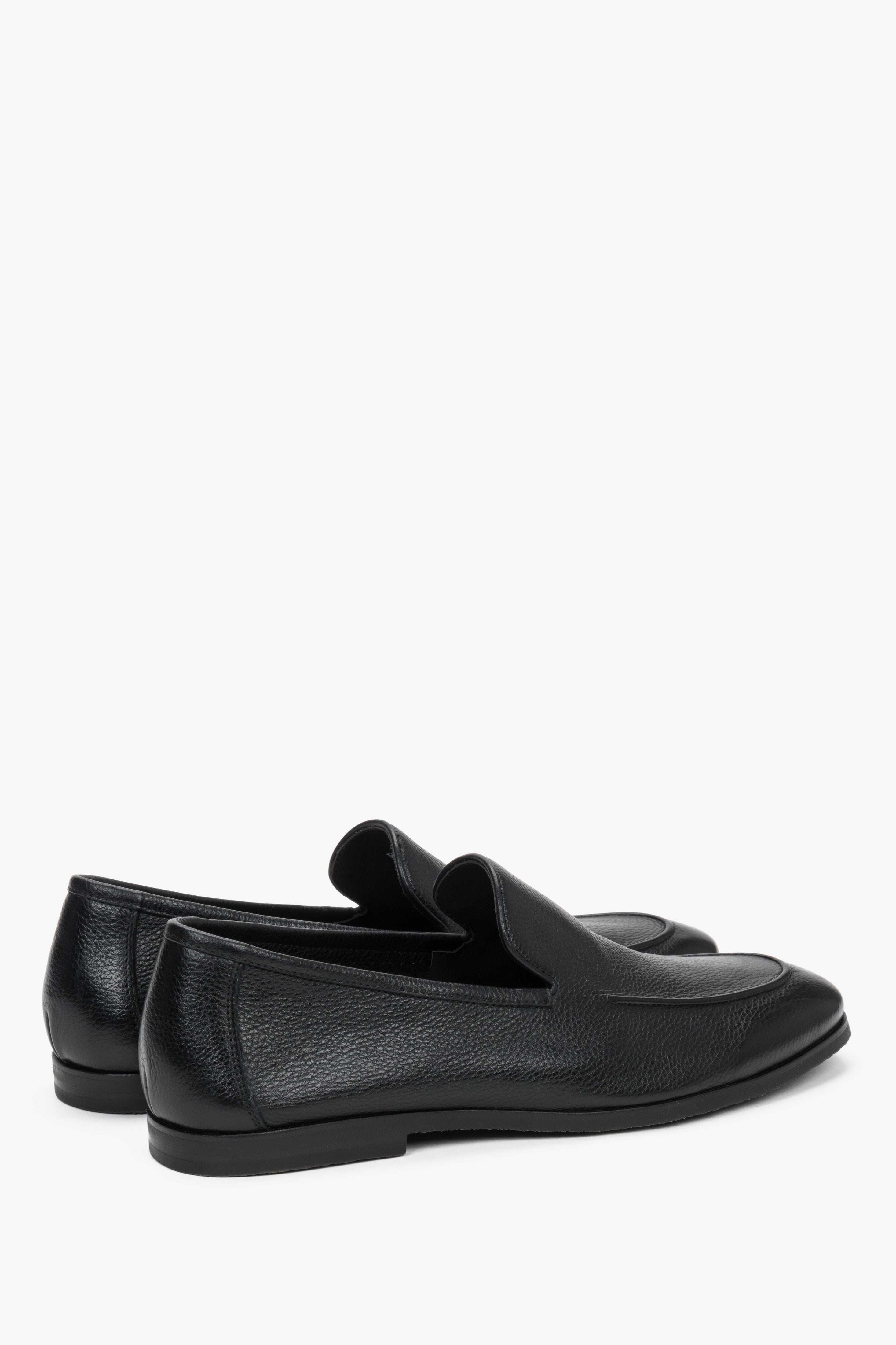 Close-up of the raised decorative seams on black genuine leather loafers.