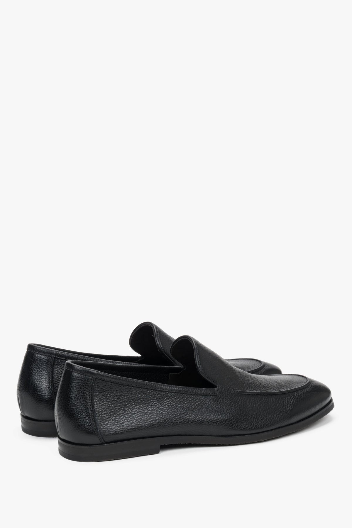 Close-up of the raised decorative seams on black genuine leather loafers.