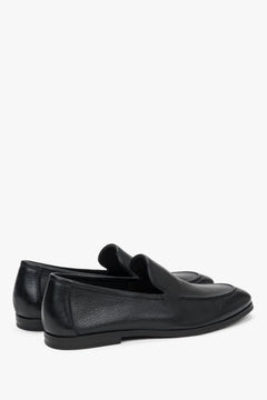 Close-up of the raised decorative seams on black genuine leather loafers.
