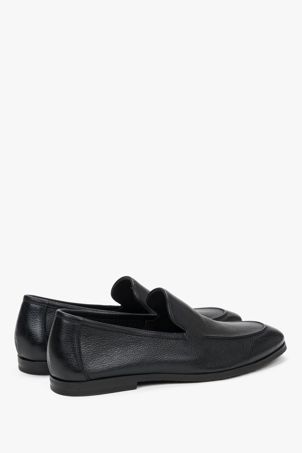Close-up of the raised decorative seams on black genuine leather loafers.