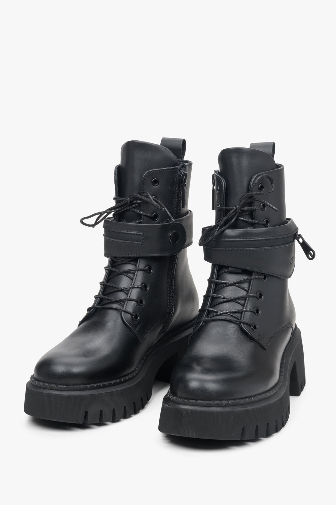 Women's black leather boots with a decorative strap and laces.
