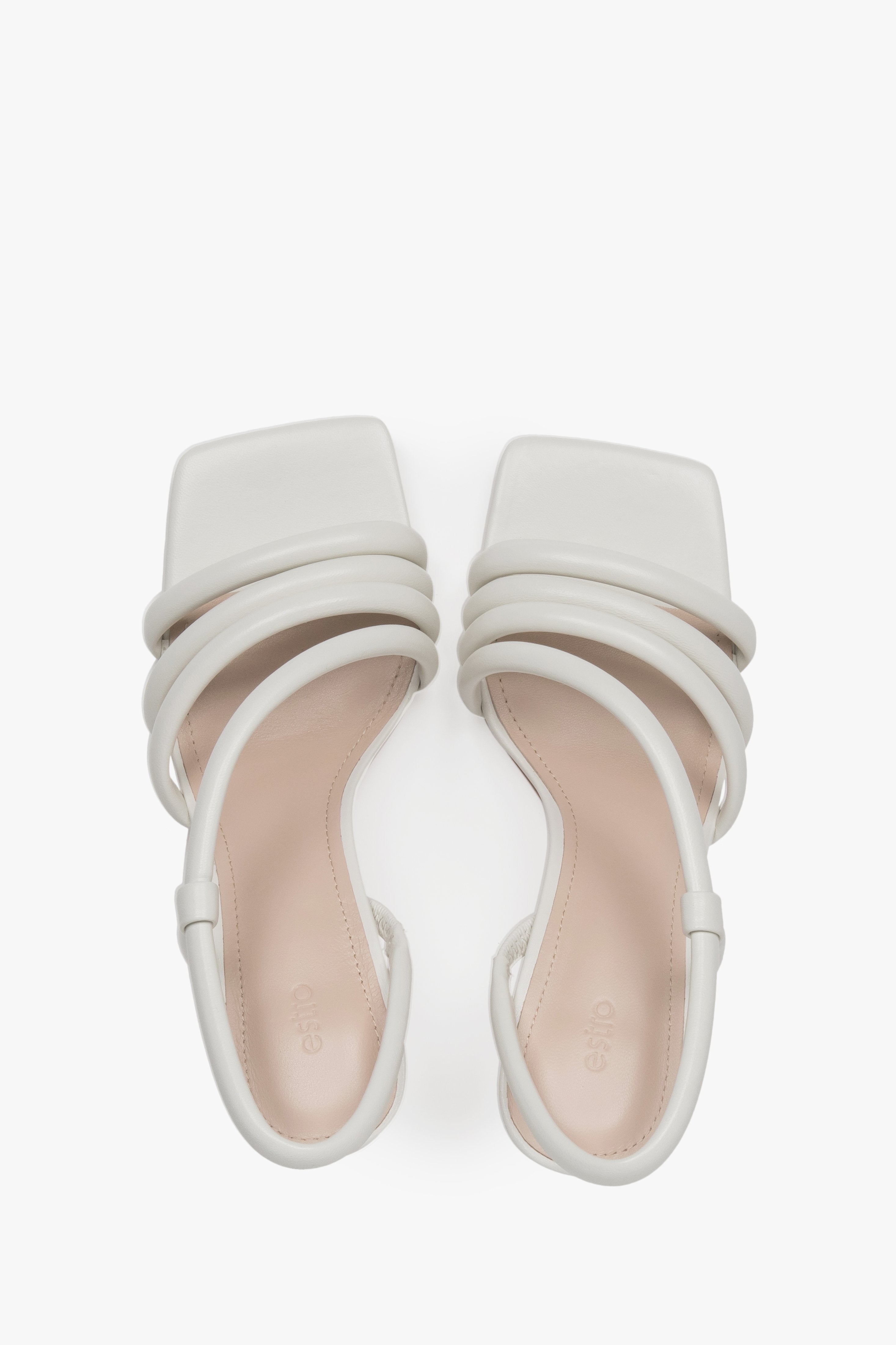 A top view of the pair of slip-on sandals, highlighting the luxury genuine chevro leather insole with a subtly embossed Estro logo.