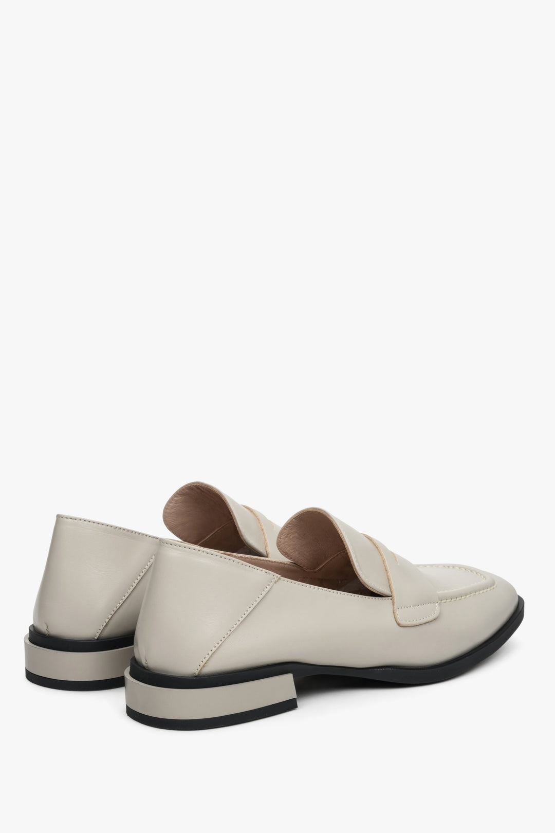 Women's beige loafers made of genuine leather with a low heel - close-up on the heel and side seam.