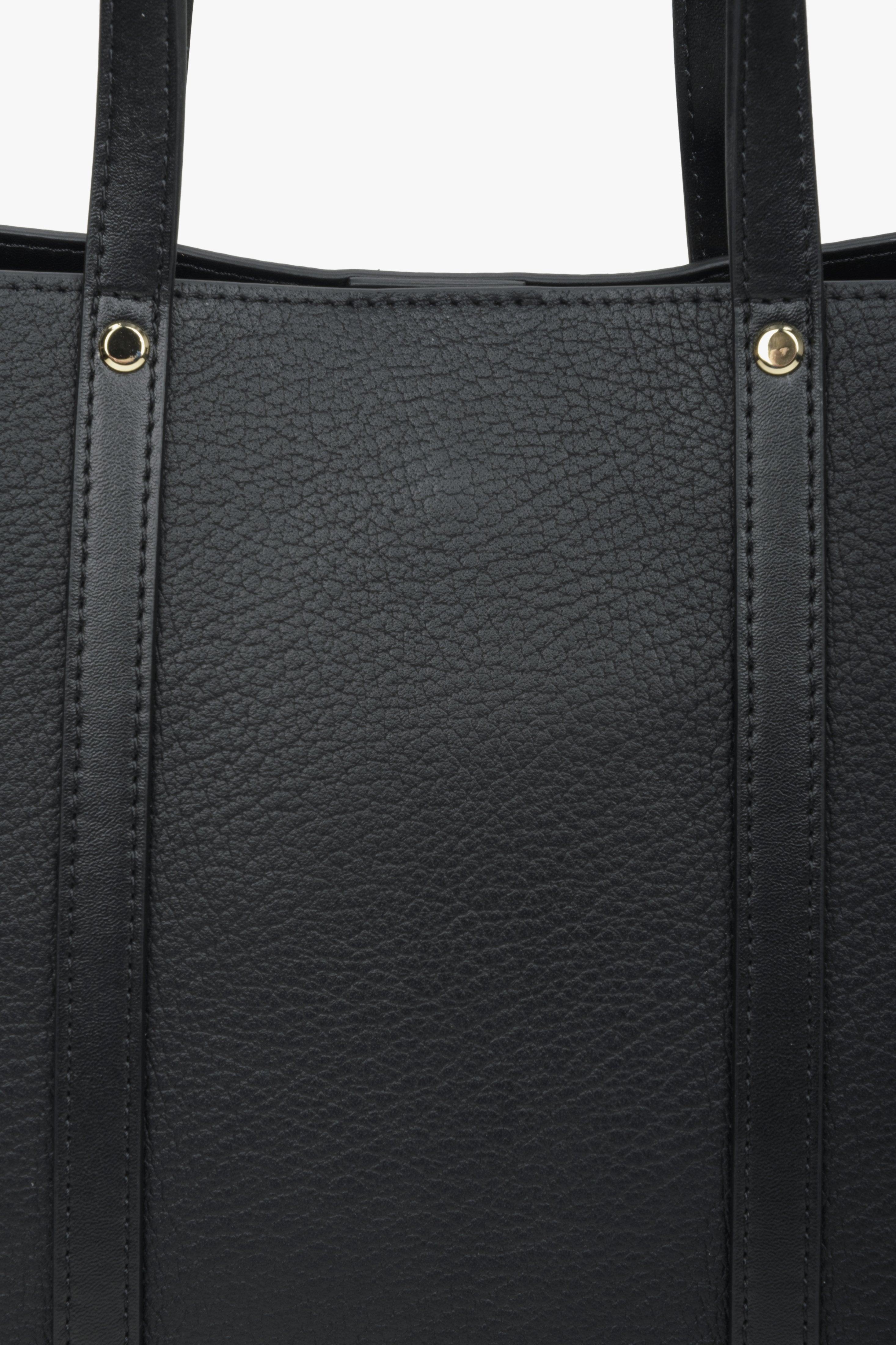 Women's black shopper bag made of genuine leather - close-up on details.