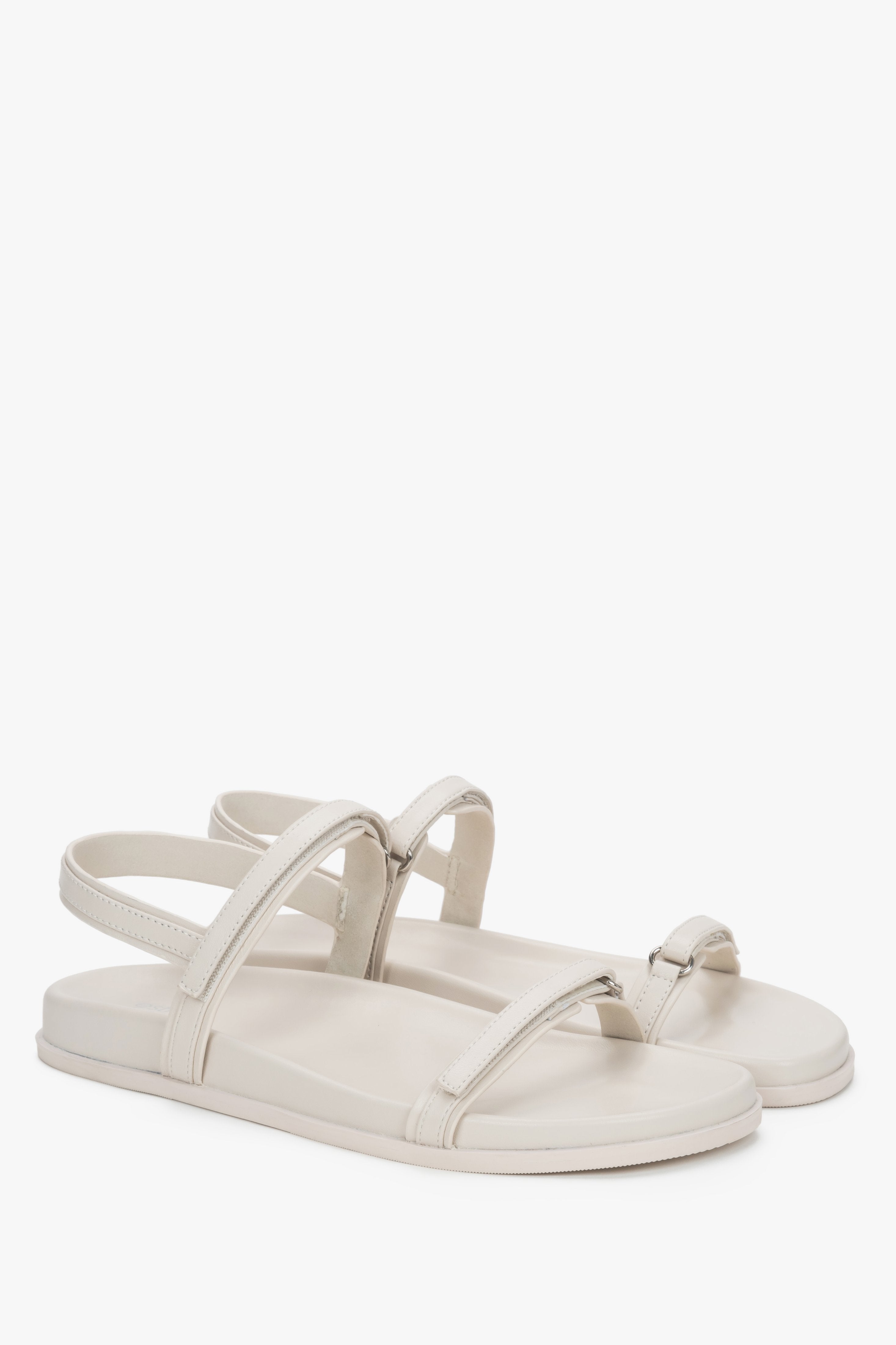A pair of women's flat sandals in an off-white color, crafted from genuine natural leather.