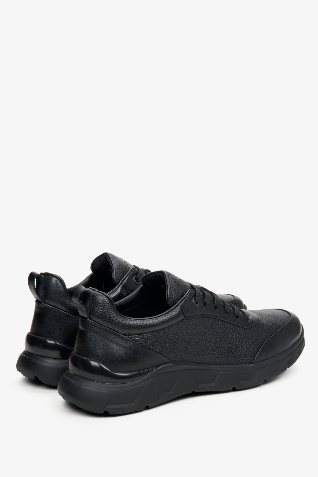 Men's black sneakers made of textured genuine leather by Estro - close-up on the side line and heel of the shoes.