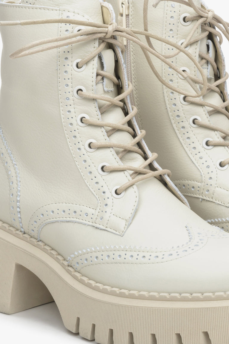 Women's light beige heeled andkle boots - a close-up on decorative lacing.