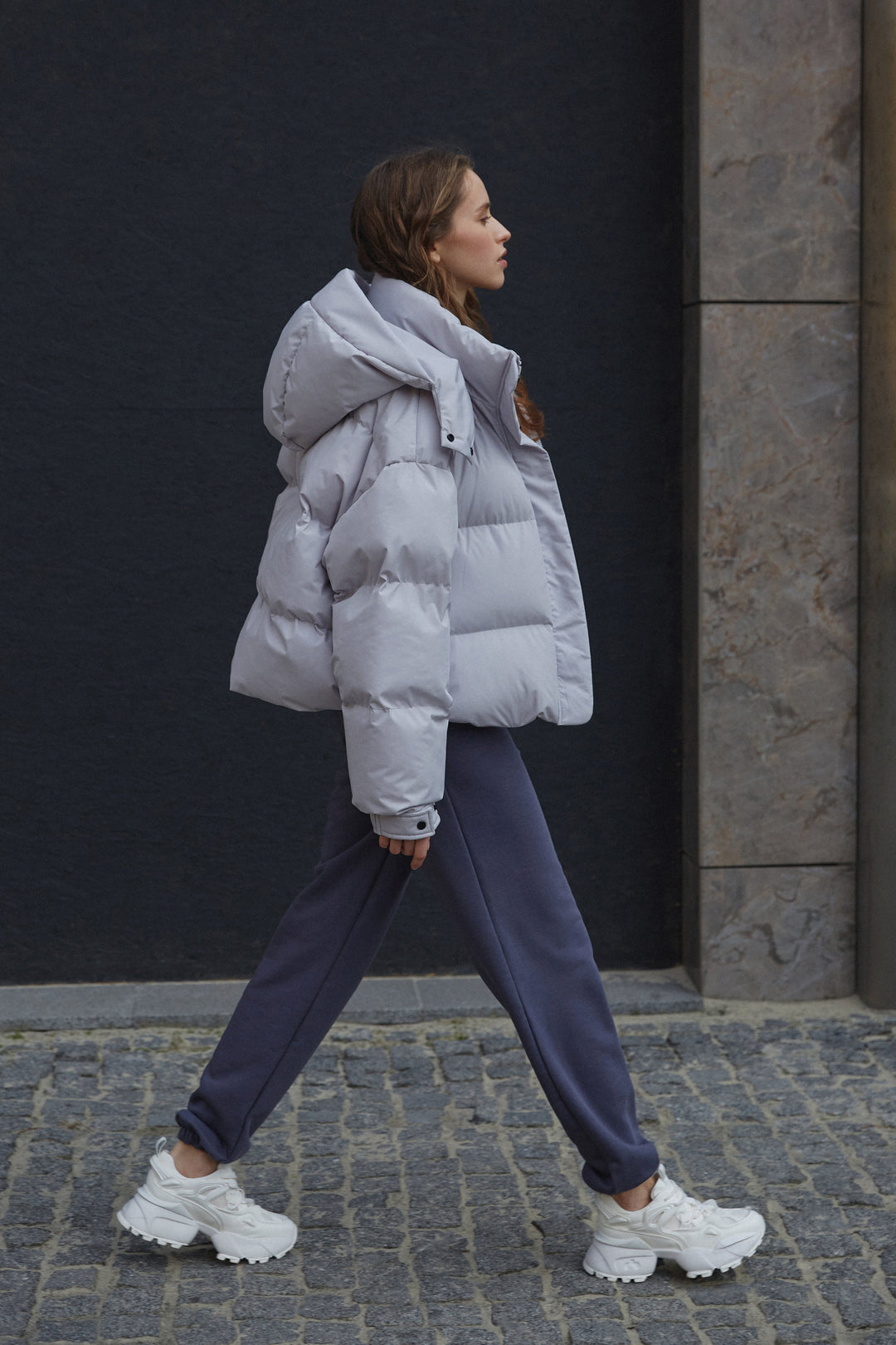 Grey women's puffer jacket by Estro - side view.