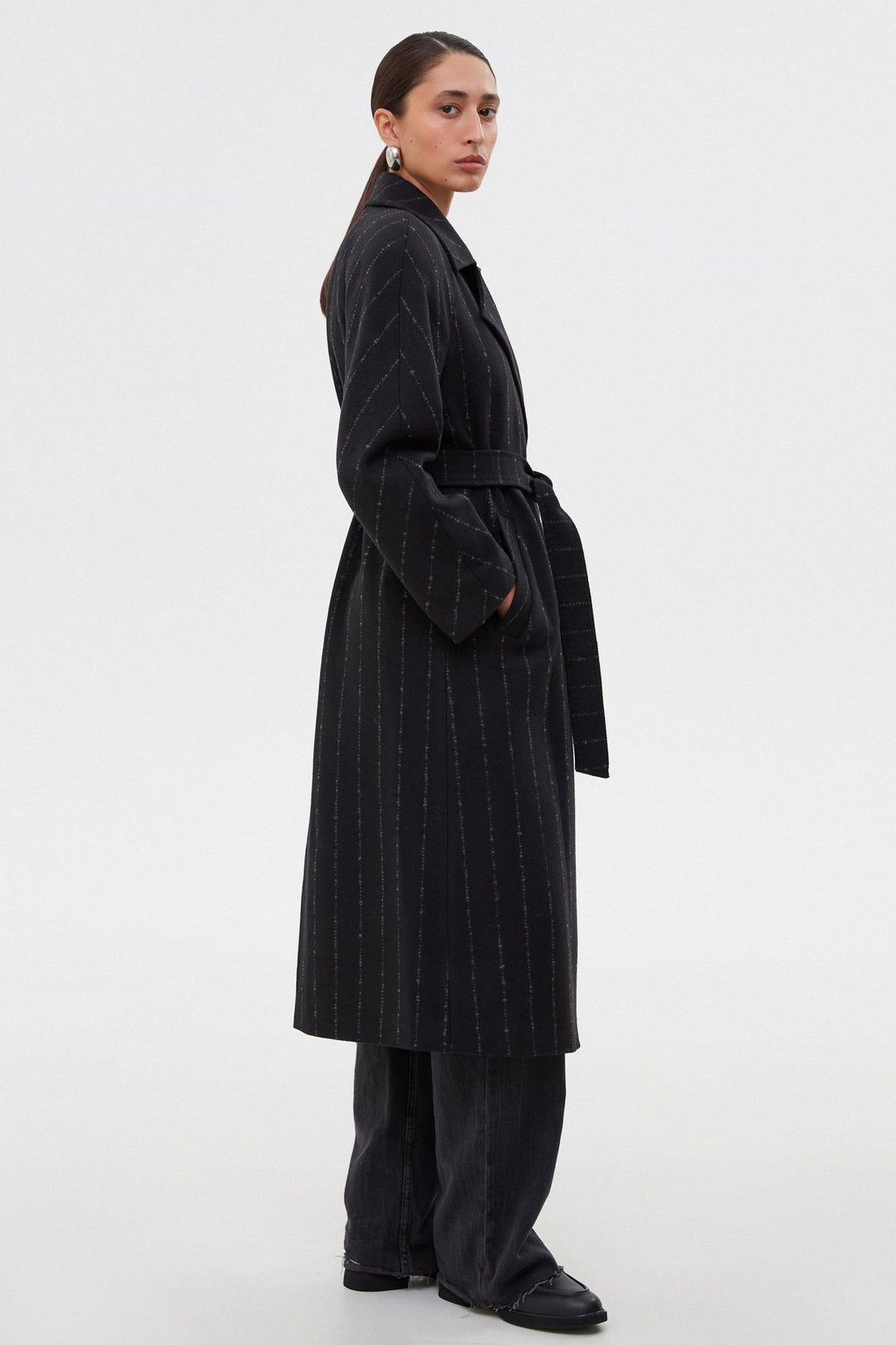 Black long women's pinstripe coat - profile of the model by Estro.