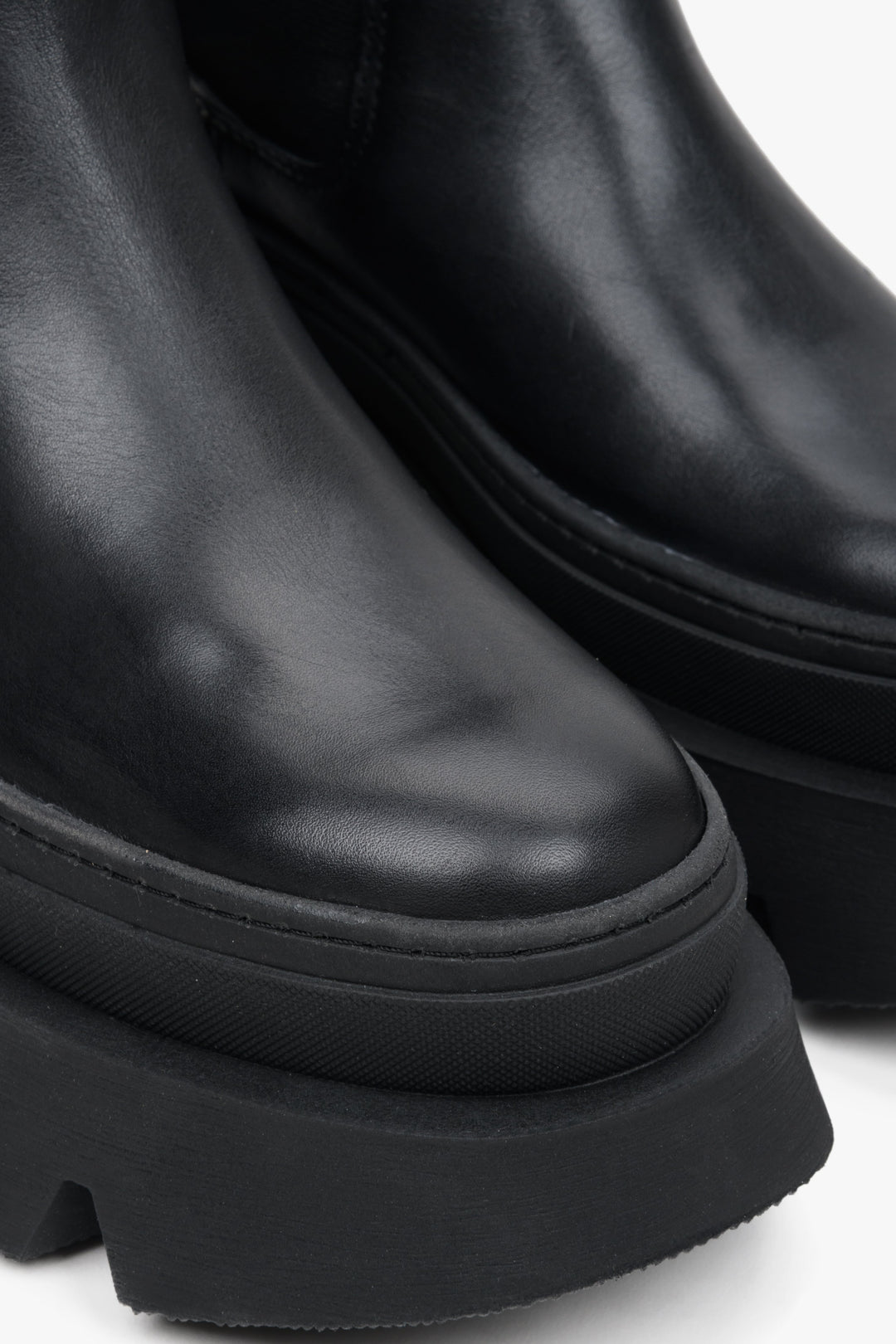 Stylish women's black ankle boots on a thick sole by Estro - close-up on the rounded toe of the model.