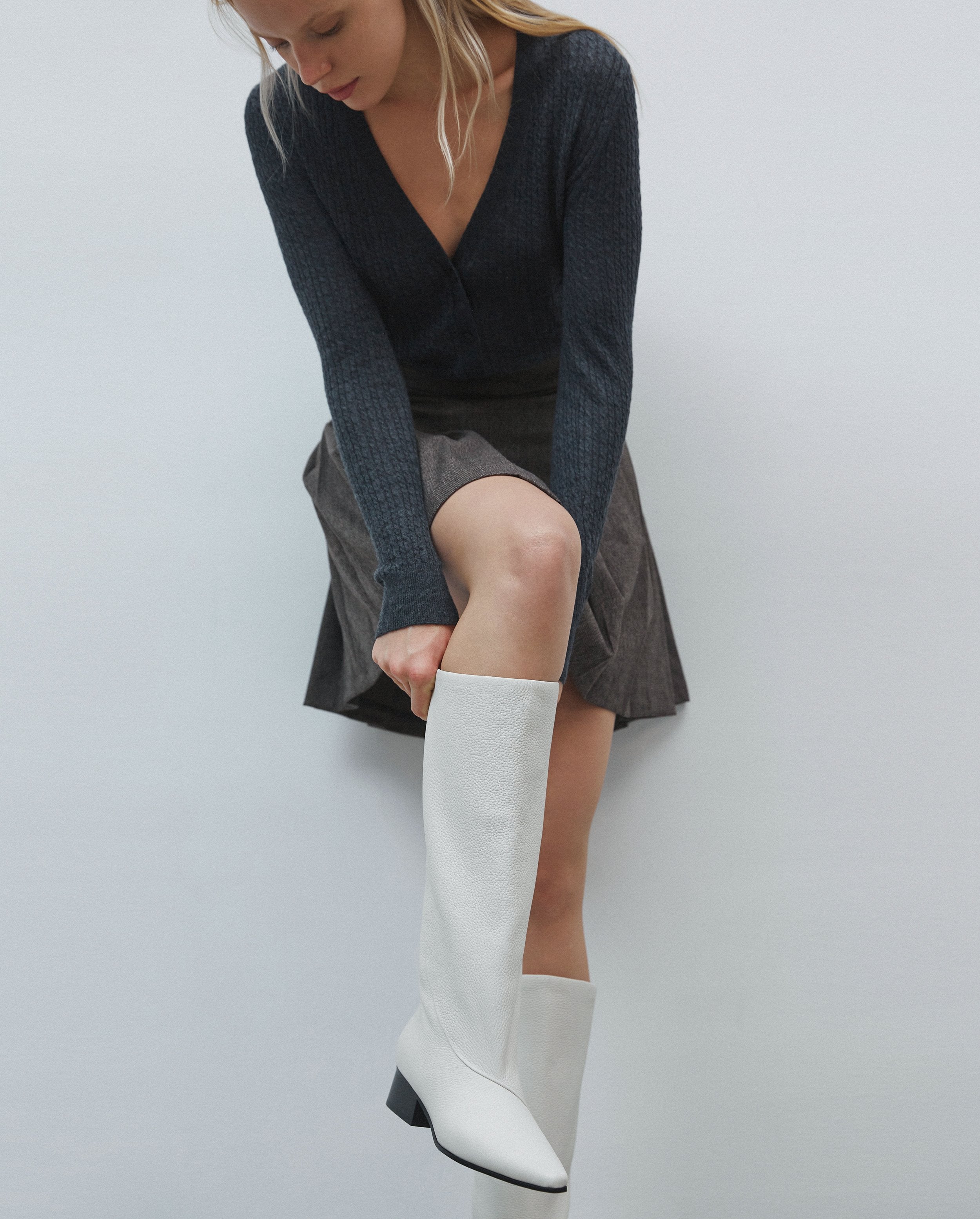 Women's white leather boots with a pointed toe - presentation on a model.