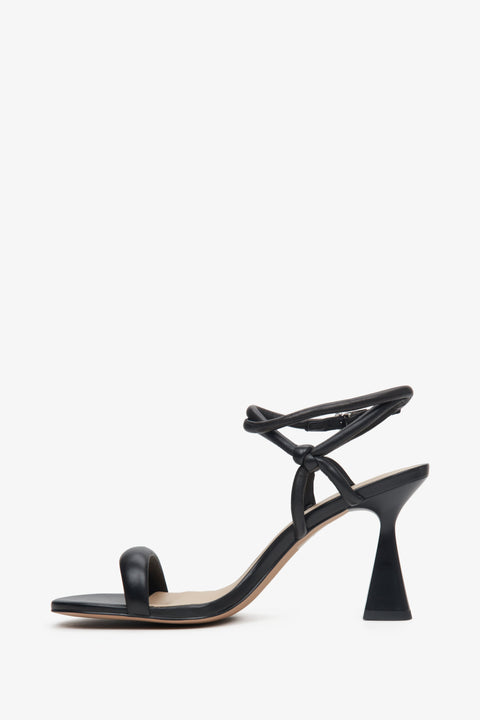 Women's black strappy sandals on a funnel heel - shoe profile.