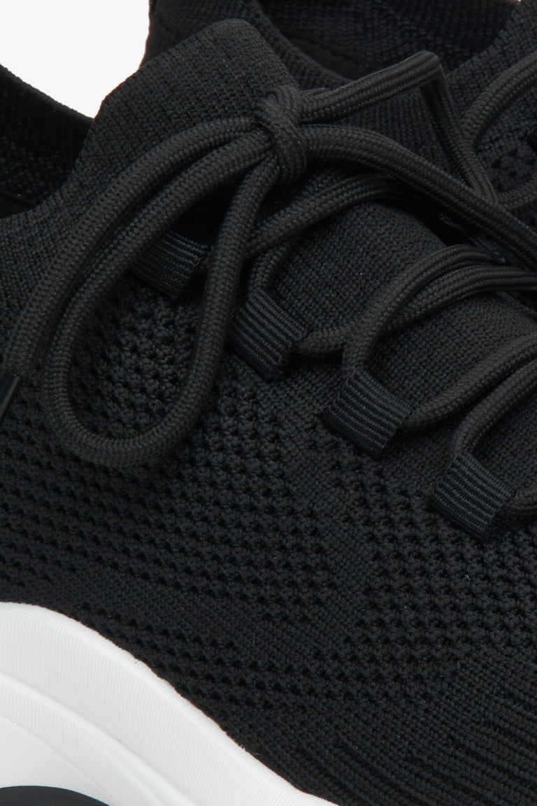 Black women's mesh sneakers on elastic sole - a close-up on details.