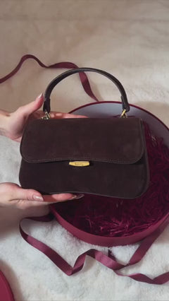 Small dark brown women’s satchel handbag made of genuine velour.