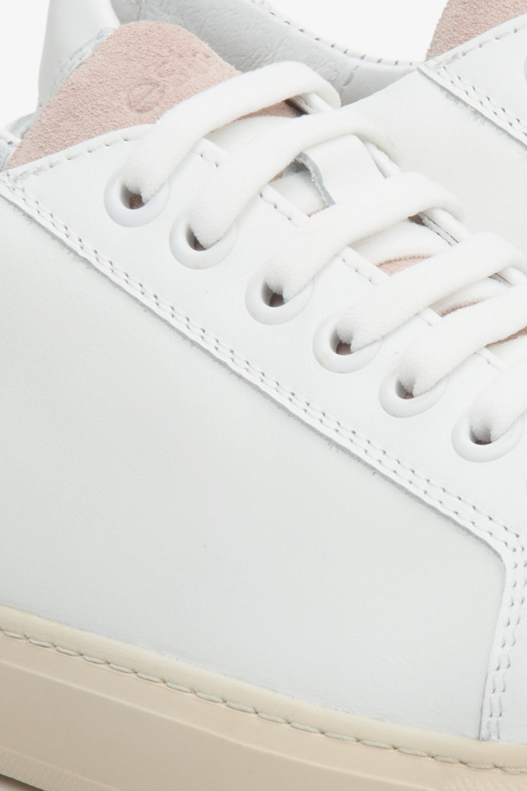 Women's white and pink sneakers made of genuine leather and velour - close-up on the lacing system.