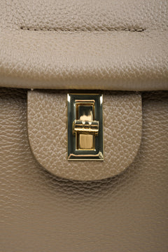 Women's brown boxy-style handbag - close-up of the gold clasp.
