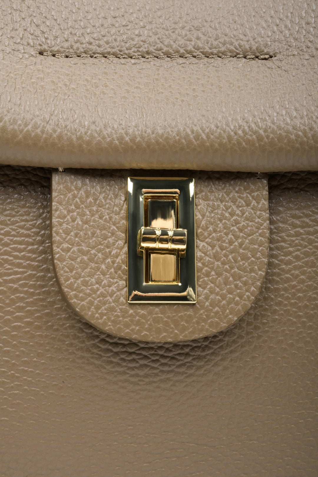 Women's brown boxy-style handbag - close-up of the gold clasp.