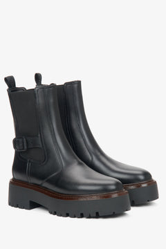 Women's black leather ankle boots with a decorative buckle by Estro.