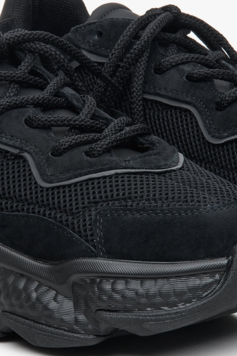 Women's black sneakers with suede and textile on a chunky sole - close-up on the details.