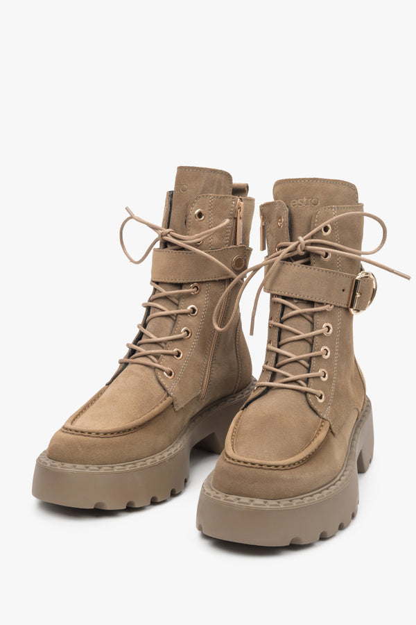 Brown women's work boots by Estro made from natural velour with laces and a zipper, as well as a decorative buckle - close-up on the front of the shoe.