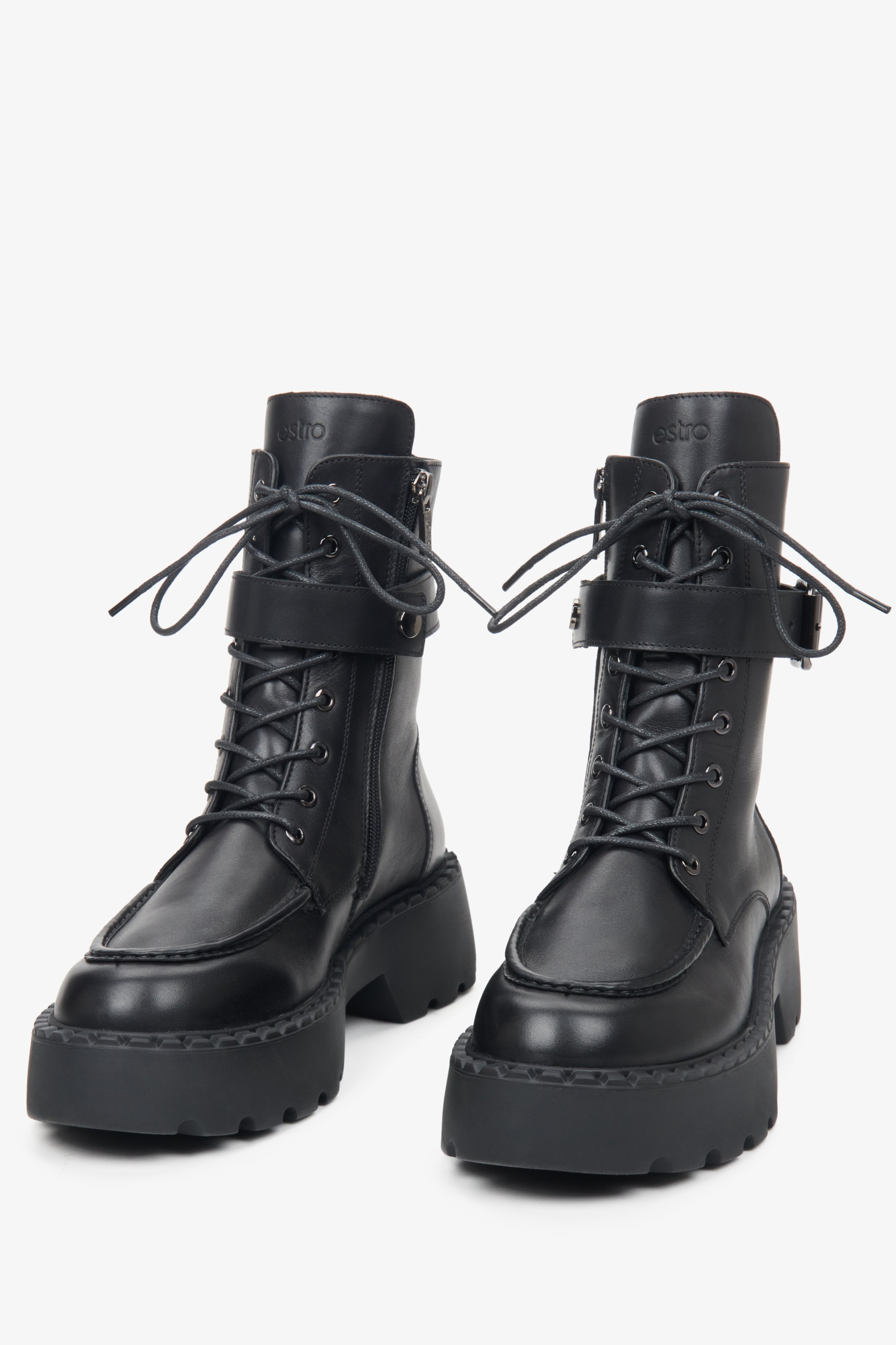 Leather women's black Estro boots with a decorative strap and silver embellishments - close-up on the toe and lacing system.