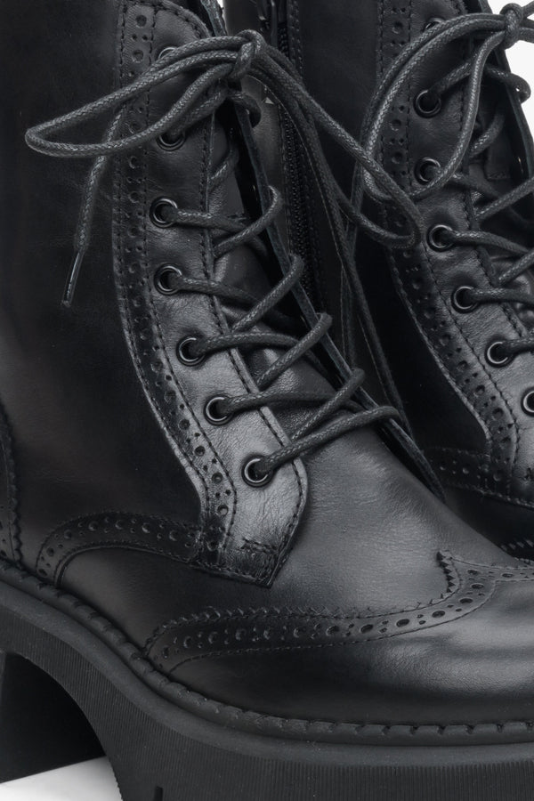 Women's black heeled andkle boots - a close-up on decorative lacing.