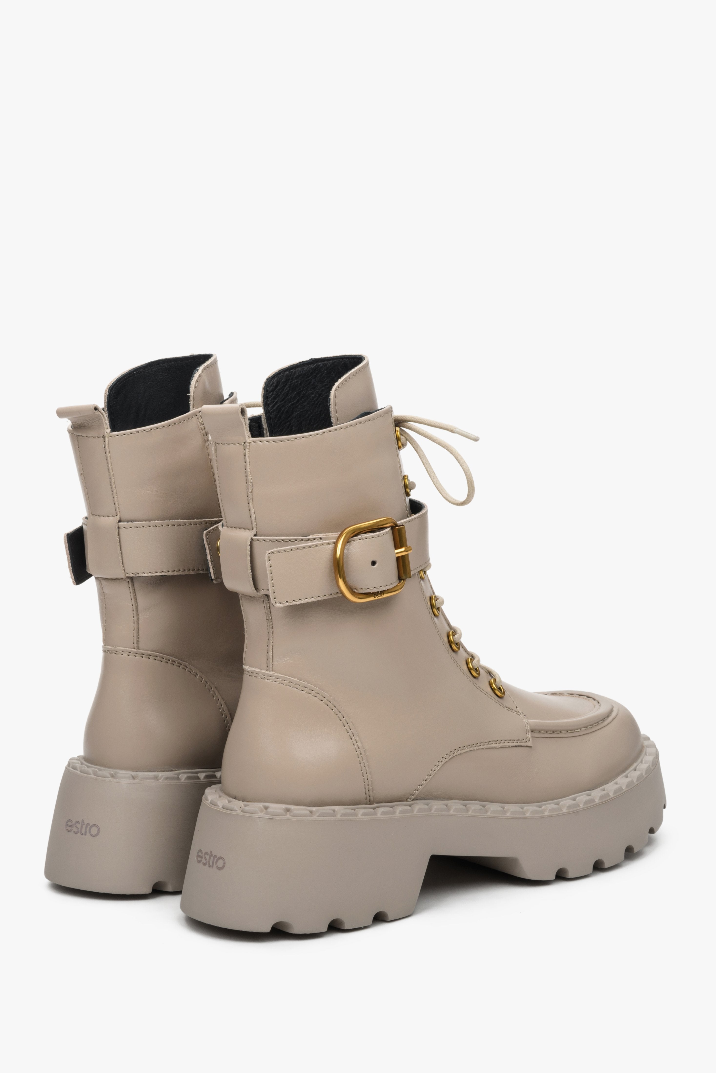 Women's beige leather combat boots with a decorative strap and gold accents - close-up on the side and back of the boot.