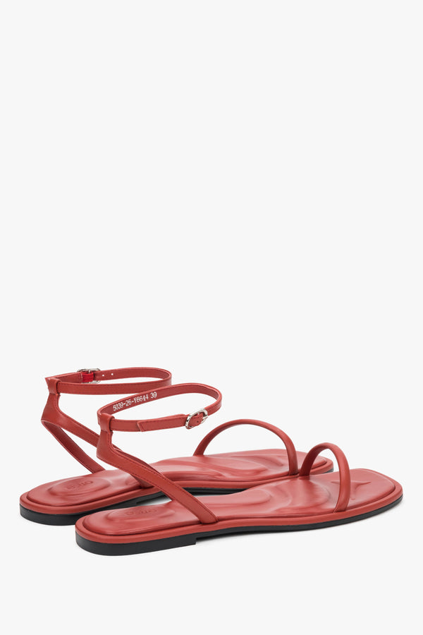 Minimalist red sandals made of genuine leather with thin straps, designed for comfort.