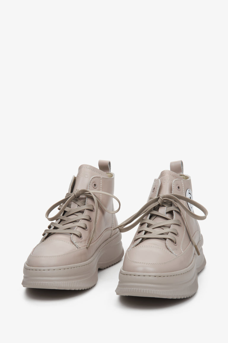 Beige high-top women's sneakers in beige colour - close-up on shoe toeline.