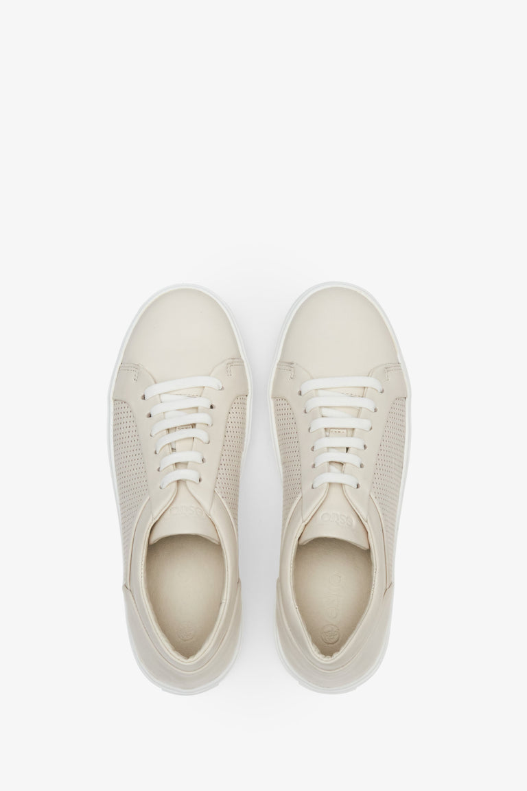 Perforated women's summer sneakers made of beige genuine leather - presentation of footwear from above.