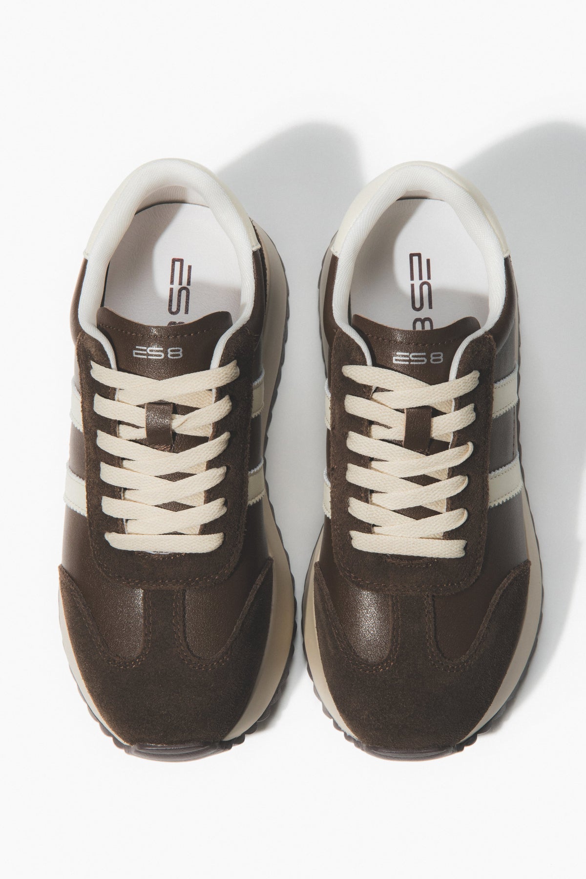 Pair of brown sneakers with white laces.
