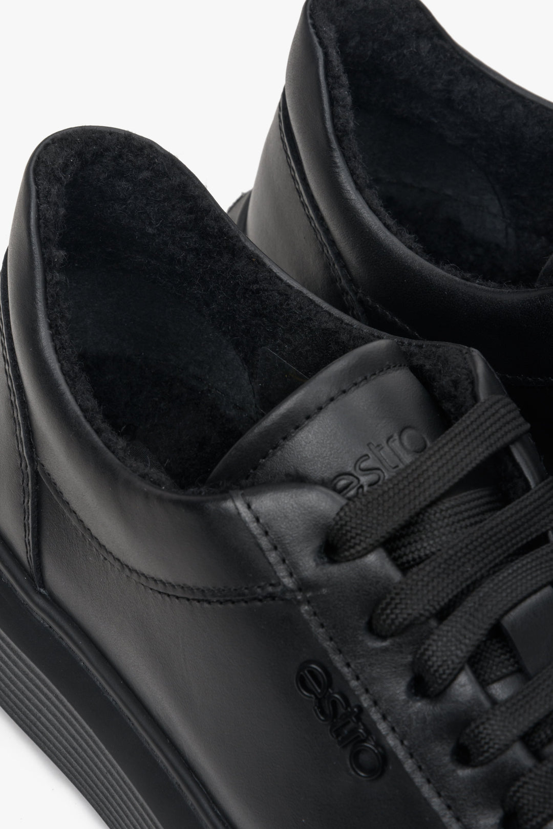Black, insulated low-top sneakers made of genuine Italian leather - close-up on details.