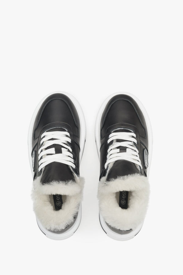 Black insulated women's sneakers made from genuine leather with fur lining - presentation of the footwear from above.