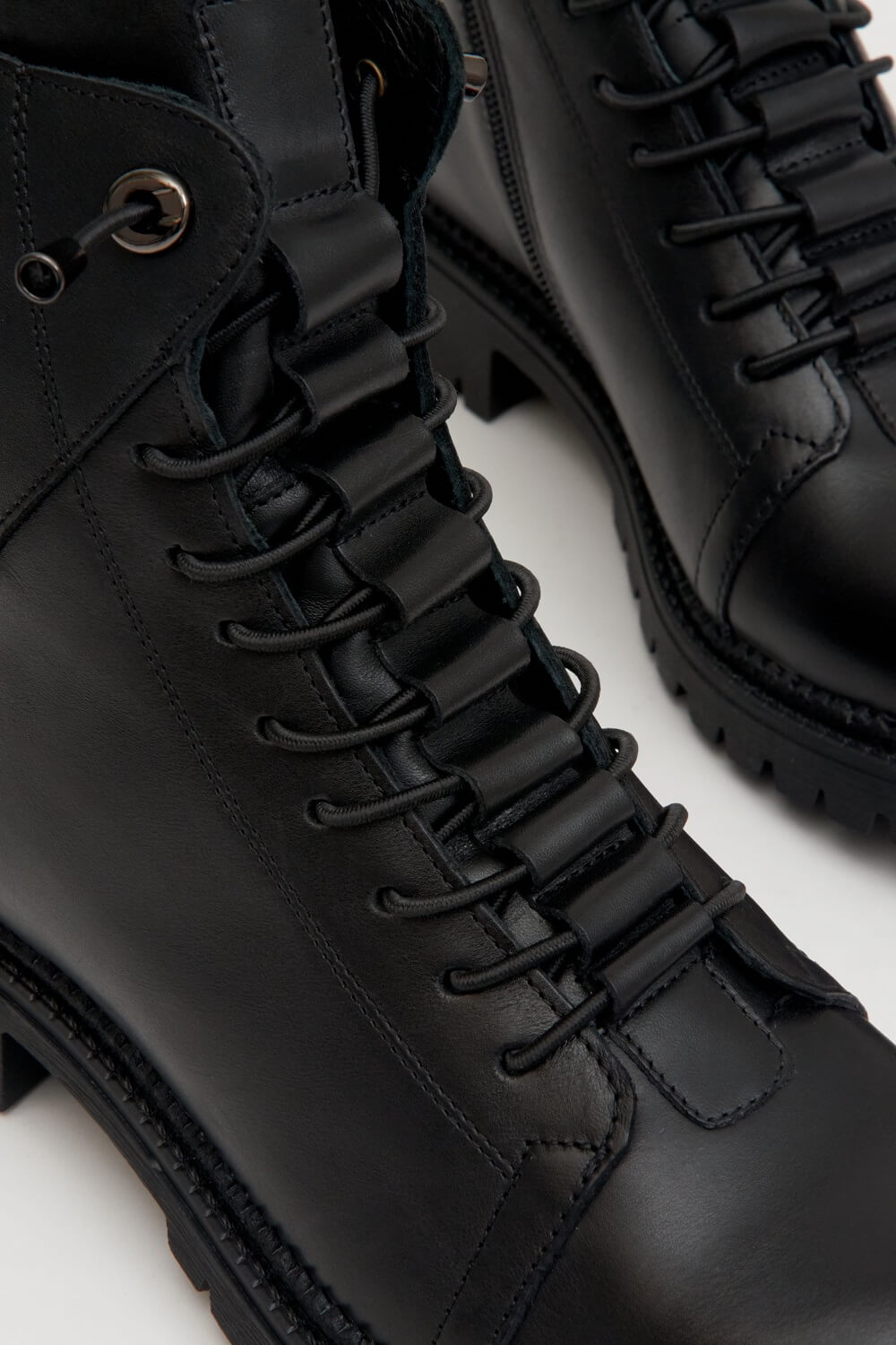 Women's black winter boots made of genuine leather - close-up on the lacing.