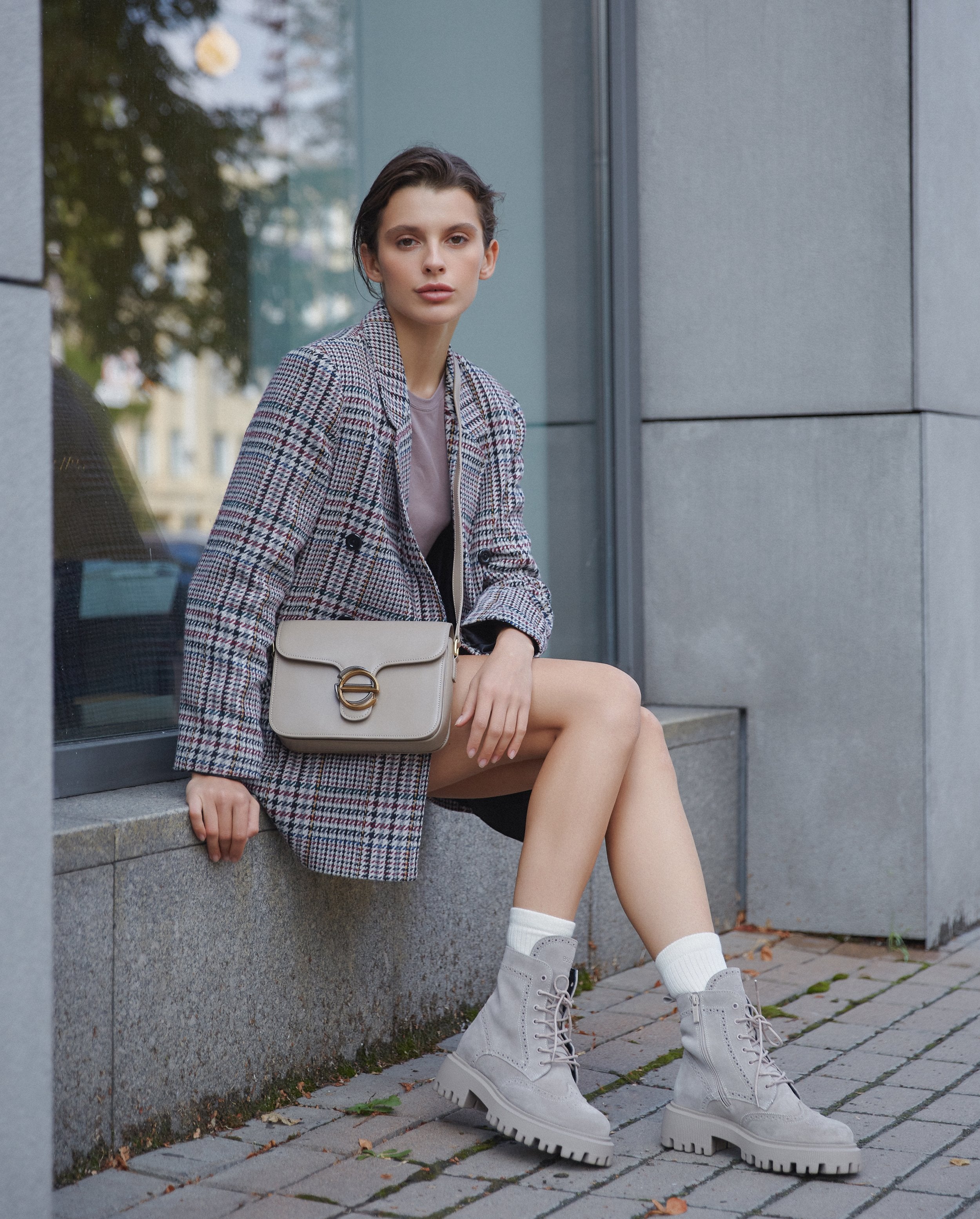 Women's small grey and beige handbag with gold hardware made of leather by Estro, perfect for spring and fall  - presentation on a model.