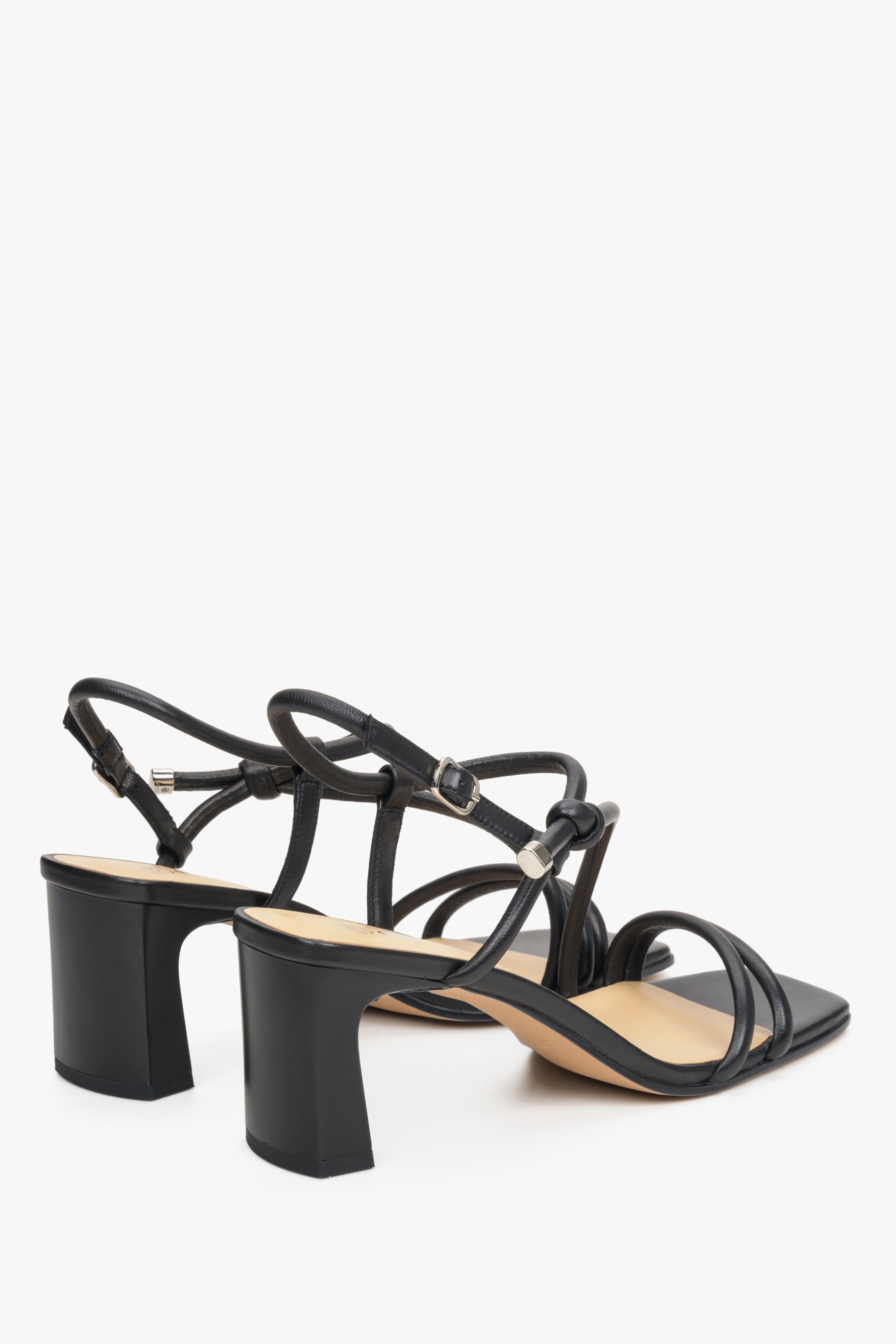 Black leather strappy sandals on a block heel, presentation of the heel and sideline.
